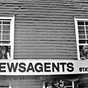 people watching from windows above newsagents