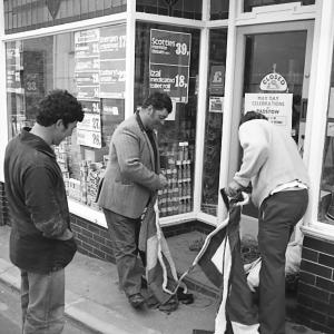 men putting up flags outside shop