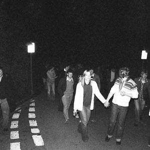 people walking in road at night