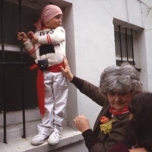 Child stood on window sill held up by woman