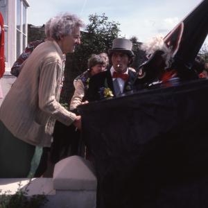 Old Oss greeting women at their house
