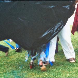 Man and woman's legs under Blue Ribbon Oss costume