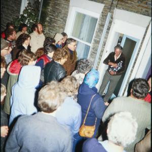 Night time, woman looking down on street from upstairs window