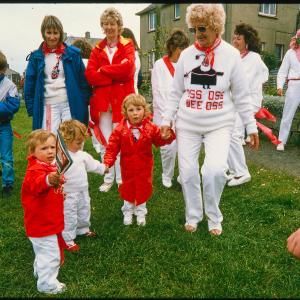 Children holding hands with lady from Old Oss and holding teasing club