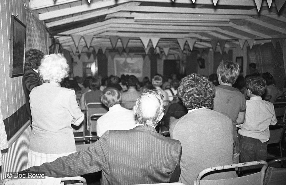 People watching slide show presenting Doc Rowe's photos