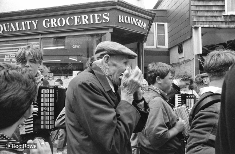 man playing harmonica in street