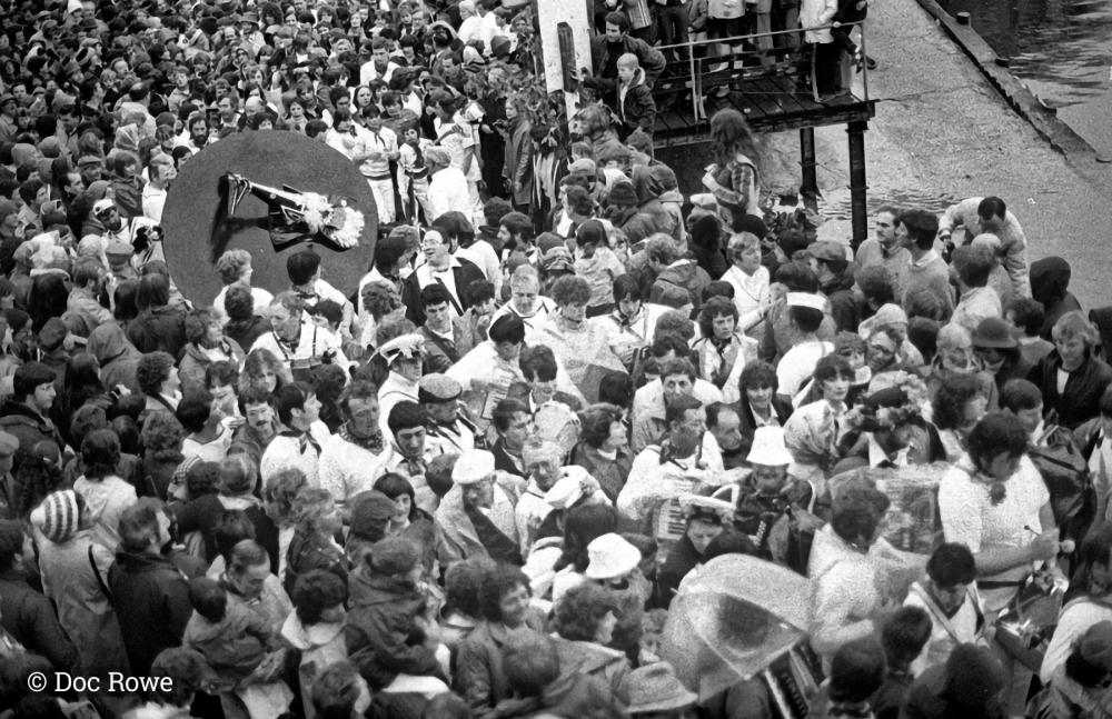 Wide shot of crowds and people following Blue Ribbon Oss