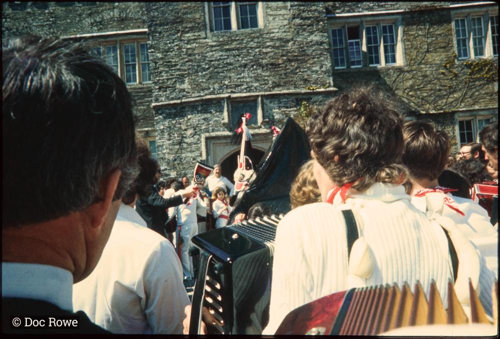 Old Oss being teased at Prideaux Place, view over shoulders of accordion players