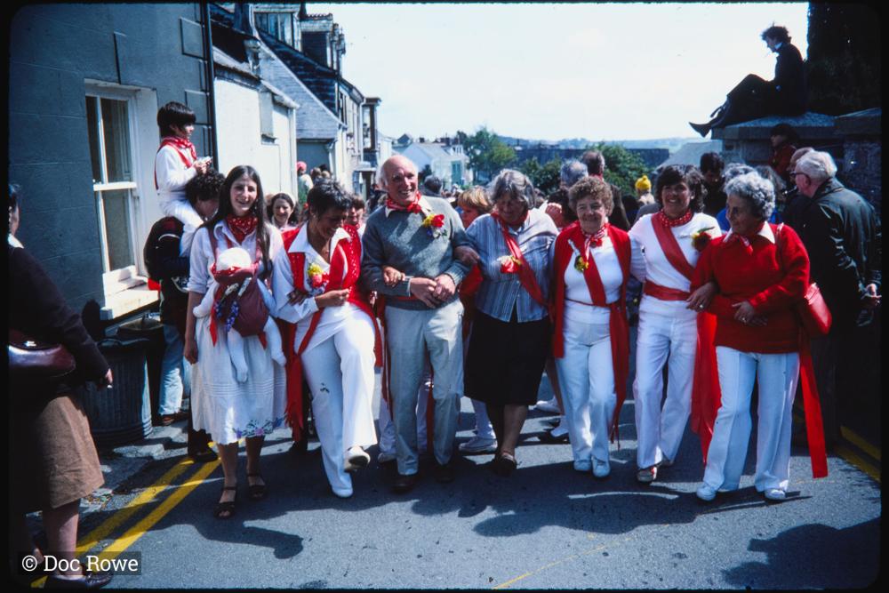 Old Oss party wearing sashes arm in arm