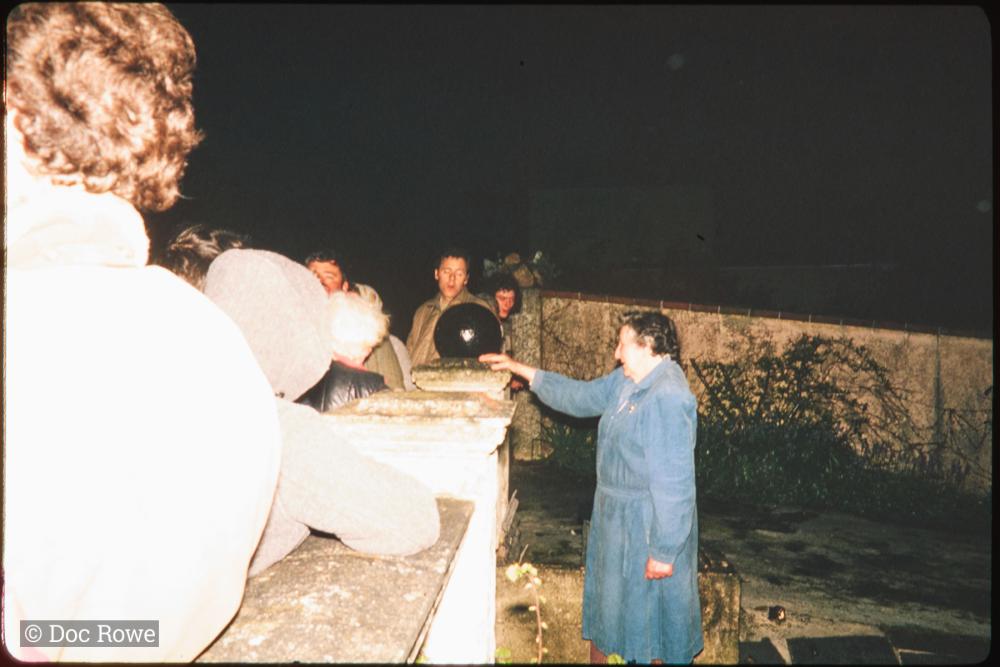 Woman at garden wall at night