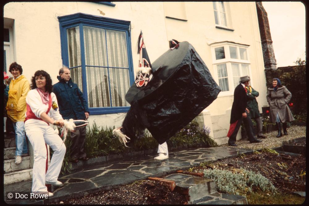 Old Oss dancing in someone's garden and Master of Ceremonies greeting women at their front door