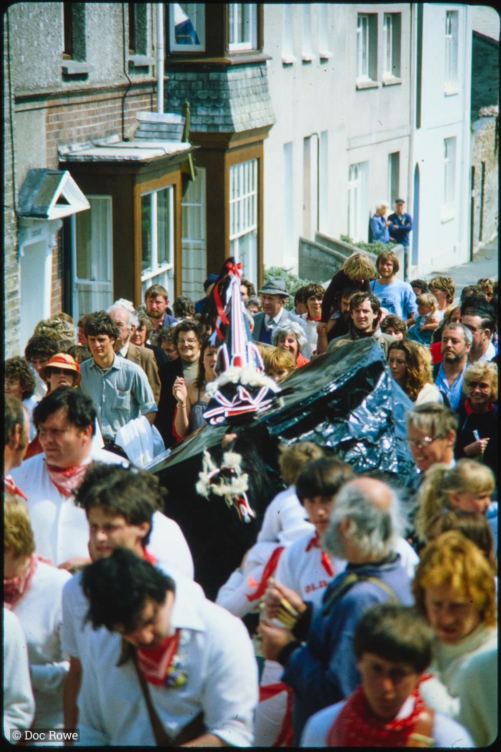 Old Oss walking amongst crowd of locals and musicians