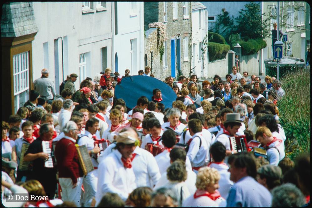 Old Oss rider amongst procession in road, without hat on