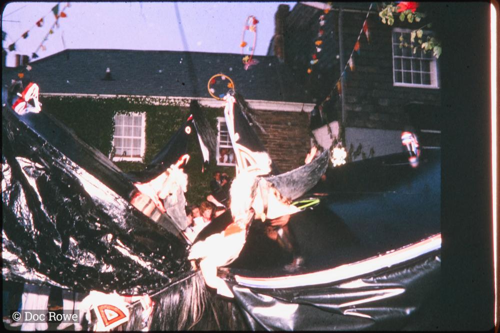Old Oss and Blue Ribbon Oss dancing together at night under maypole