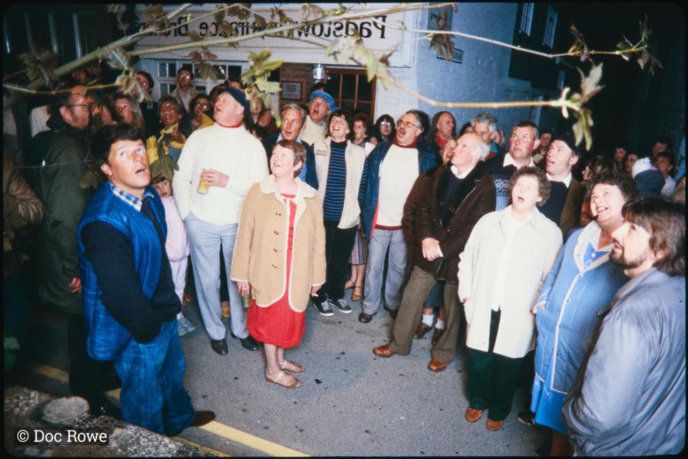 People singing on street corner at night
