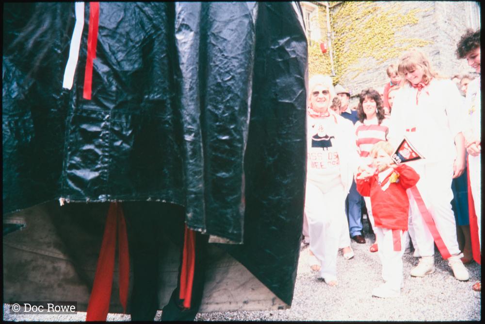 Child with teasing club, half photo obscured by oss