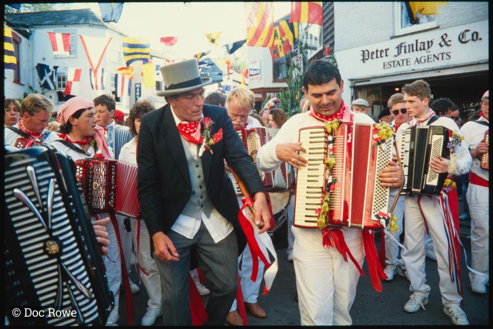 Old Oss Master of Ceremonies and accordion players leading procession through town