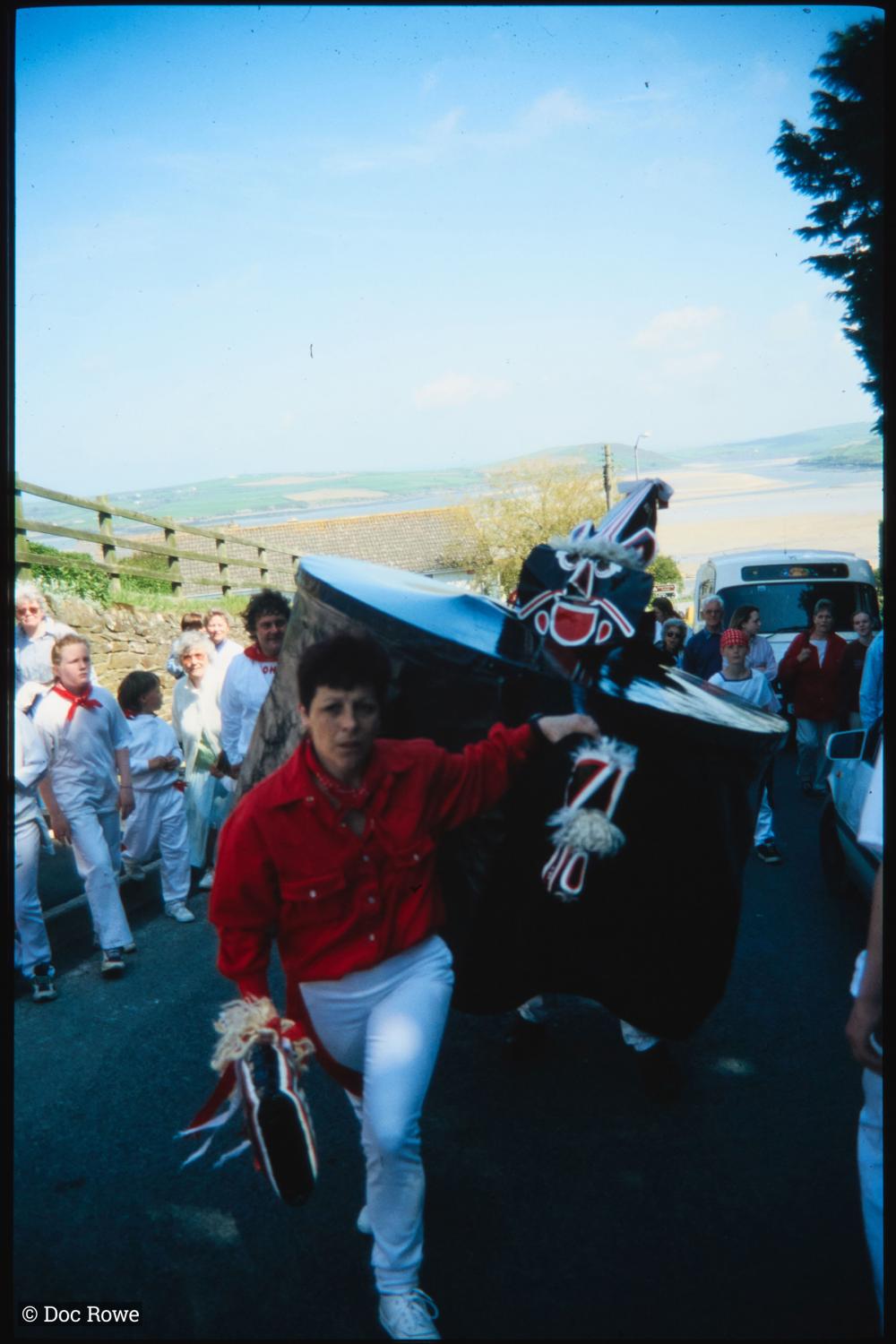 Woman dancing in front of Old Oss, with view of sea behind